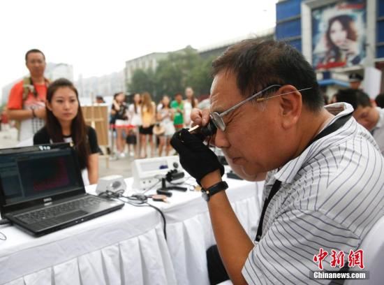 资料图：在北京崇文门街边举行的寺库奢侈品鉴宝会，吸引众多路人排队鉴宝。 <a target='_blank'  data-cke-saved-href='http://www.chinanews.com/' href='http://www.chinanews.com/'>中新社</a>发 杜洋 摄