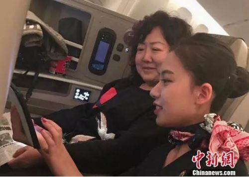 空乘人员指导乘客连接机上Wifi。图片来源 <a target='_blank'  data-cke-saved-href='http://www.chinanews.com/' href='http://www.chinanews.com/' >中新网</a>