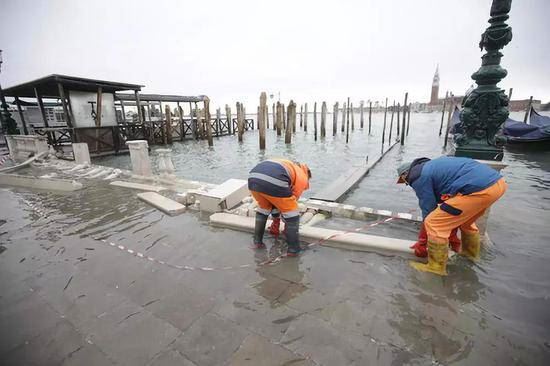  在意大利威尼斯，工作人员清理洪水冲毁的围栏。（新华社发）