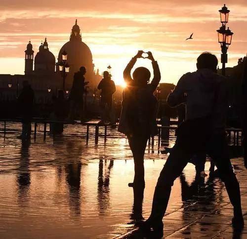  11月17日，在意大利威尼斯，人们在洪水中欣赏落日。（新华社发）