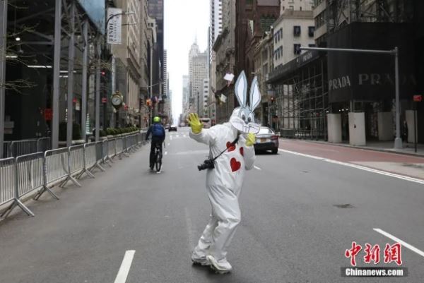 当地时间4月12日，西方传统节日复活节，一位市民身穿防护服、头戴防护面罩在纽约曼哈顿第五大道装扮成复活节兔。(<a target='_blank' href='http://www.chinanews.com/'>中新社</a>记者 廖攀 摄)