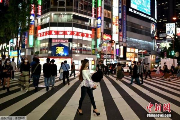 当地时间5月25日据日媒报道，日本首相安倍晋三宣布，从25日开始，解除包括东京都在内的首都圈4都县和北海道的紧急状态。这标志着日本47个都道府县将全部实现解禁。4月7日，日本紧急事态宣言以7个都府县为对象首次发布，至今已有49天。此前，日本已经解除42个府县的紧急事态宣言，加上此次解除的首都圈4都县和北海道，目前，针对所有都道府县的宣言已经全部解除。图为当地时间5月25日，人们穿过东京新宿区的一条街道。