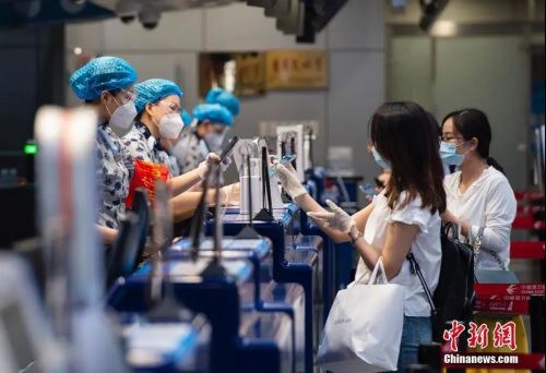 资料图：7月4日，出行的旅客在北京首都国际机场2号航站楼航司托运处出示自己的健康信息。中新社记者 侯宇 摄