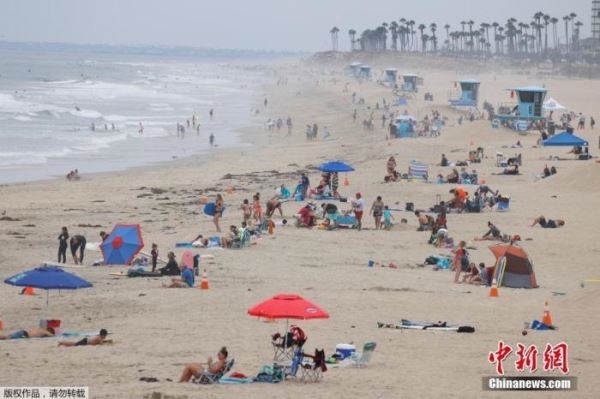 资料图：美国疫情持续蔓延，加州等地成为“重灾区”。图为加州亨廷顿海滩游客兴致不减。