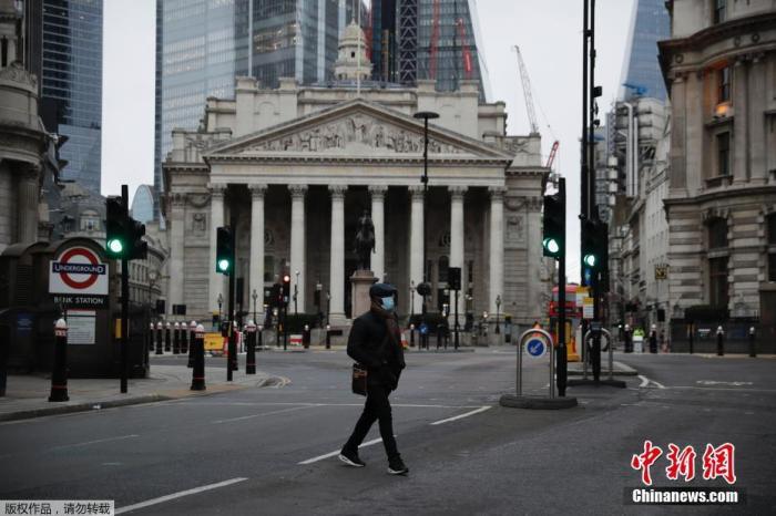 当地时间1月5日，英国采取了第三次严格性封锁措施，伦敦街头行人稀少。图为一名行人穿过英国皇家交易所前的街道。