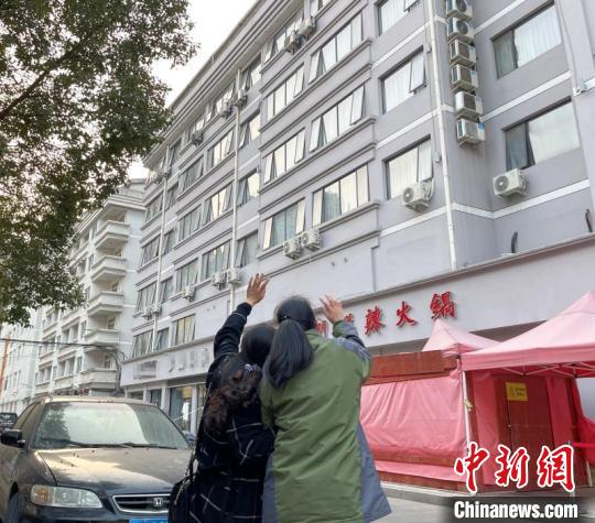 中国侨网图为迎接华侨回家的家人在医学观察点外与其挥手。　张煜欢　摄