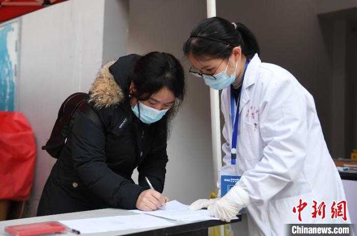 图为一位结束医学观察的华侨在离开观察点时登记信息。　王刚 摄