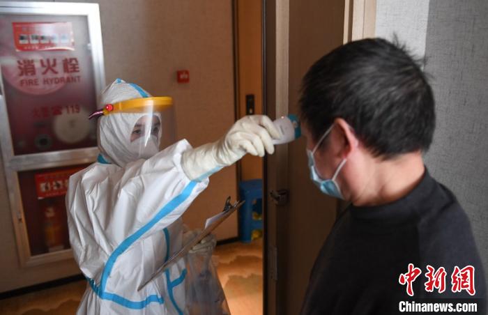 图为医学观察点工作人员对华侨测量体温，进行健康监测。　王刚 摄