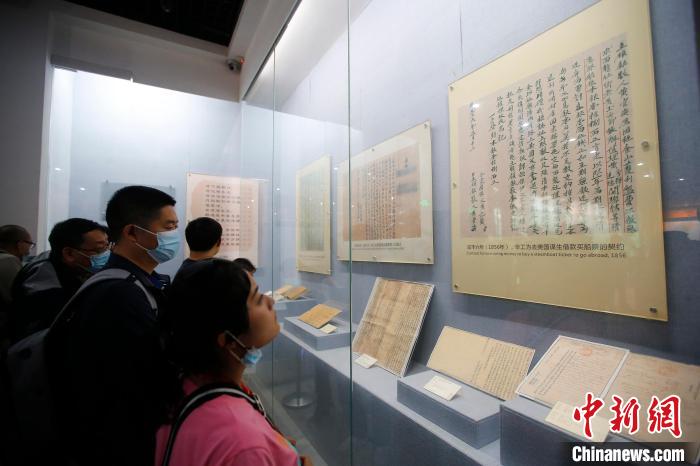 参观者正在阅览博物馆陈列的中国早期移民护照。　王骏 　摄