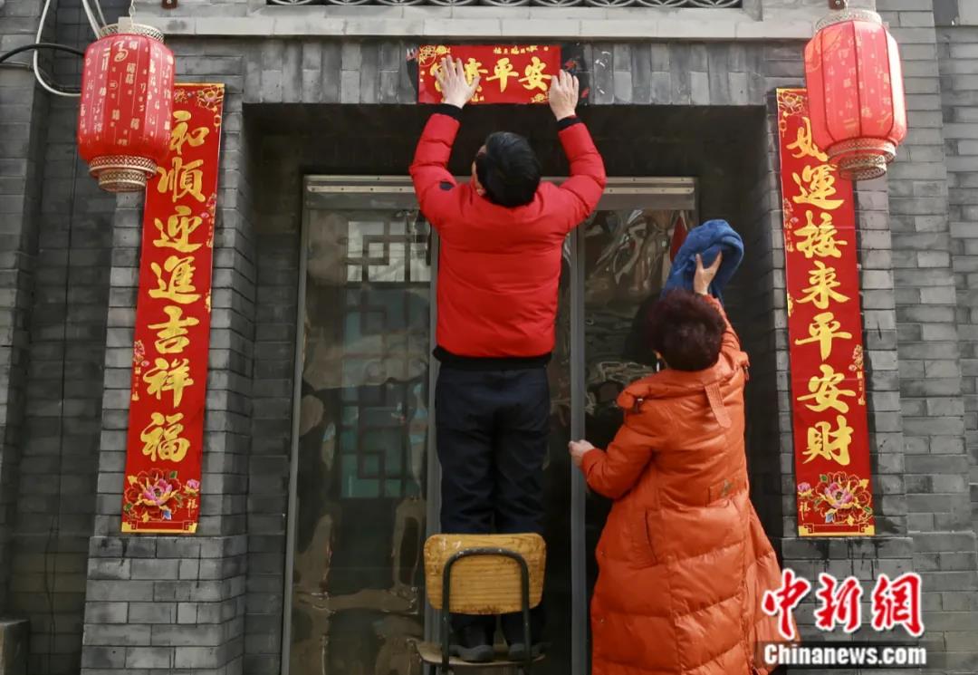 2022年1月31日，中国农历除夕，北京市民张贴春联迎接即将到来的壬寅虎年。<a target='_blank' href='http://www.chinanews.com/'>中新社</a>记者 易海菲 摄 
