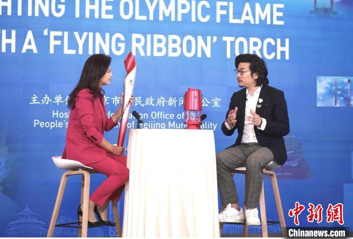 李剑叶向观众讲解火炬“飞扬”的设计理念。　2022北京新闻中心供图