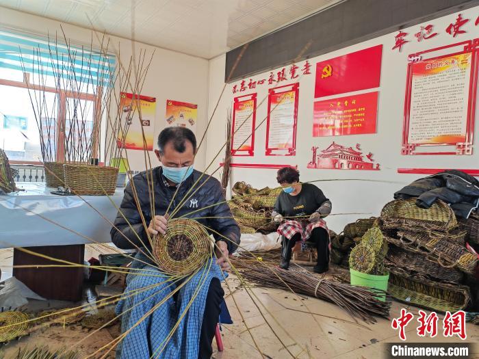 图为脱贫户丁国良在柳编扶贫车务工。　塔娜 摄