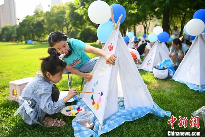 2022年7月31日，山西太原，家长与孩子共同绘制帐篷涂鸦，享受夏日假期时光。<a target='_blank' href='/'>中新社</a>记者 武俊杰 摄