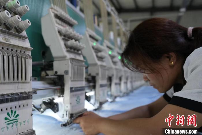 曹县一家绣花厂内工人正在检查机器。　王峰 摄