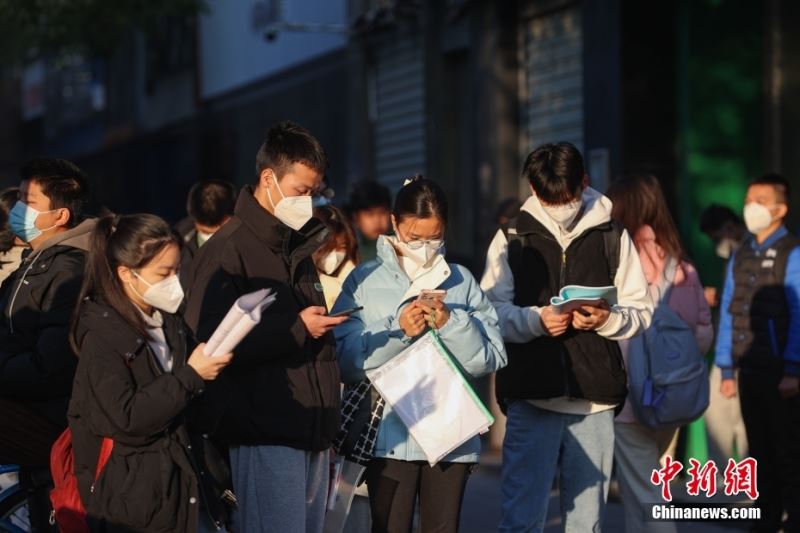 1月8日，江西南昌市第二十八中学考点外，几名考生在复习。当日，中央机关及其直属机构2023年度考试录用公务员公共科目笔试举行。<a target='_blank' href='/'>中新社</a>记者 刘力鑫 摄

