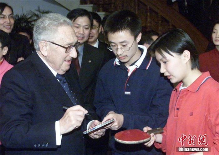 基辛格在北京钓鱼台国宾馆出席“中美乒乓外交”三十周年招待会时，为中国青年在乒乓球拍上签名。李刚 摄
